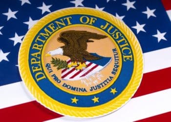 closeup of DOJ emblem on American flag