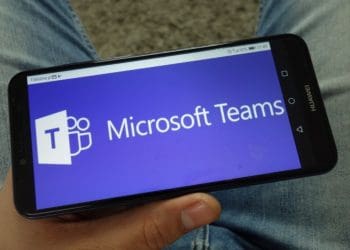 Man holding smartphone with Microsoft Teams communications platform logo