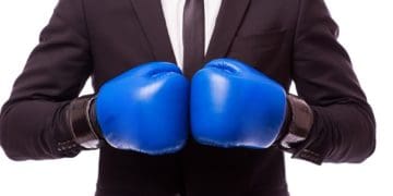 man in suit with blue boxing gloves