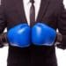 man in suit with blue boxing gloves