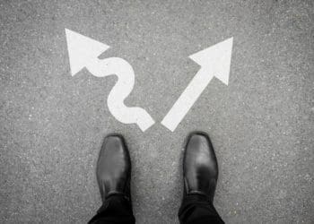 men's black shoes standing at diverging arrows