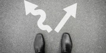 men's black shoes standing at diverging arrows