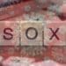 SOX spelled on wooden tiles with overlay of coronavirus