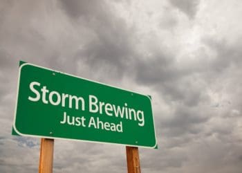 Storm Brewing Just Ahead Green Road Sign with Dramatic Storm Clouds and Sky