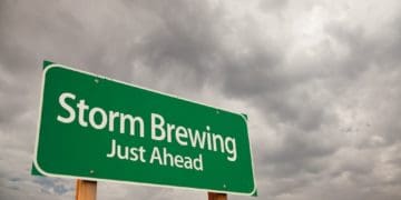 Storm Brewing Just Ahead Green Road Sign with Dramatic Storm Clouds and Sky