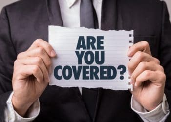 man in suit holding "are you covered?" sign