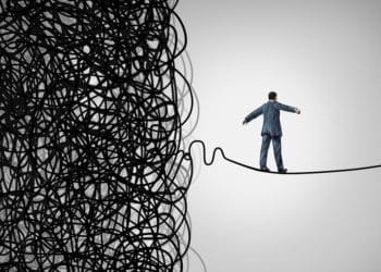 tightrope walker walking out of a confused tangled chaos of wires