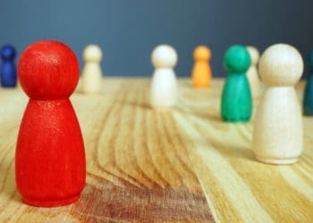 Diversity and inclusion concept. Red figure and other wooden figures.