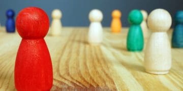 Diversity and inclusion concept. Red figure and other wooden figures.