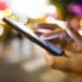 woman using smartphone in the street, city lights in background