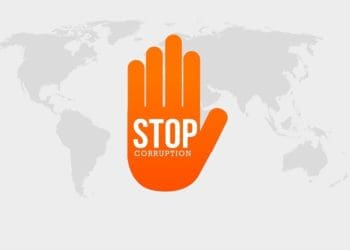 orange hand reading "stop corruption" on global map in grayscale