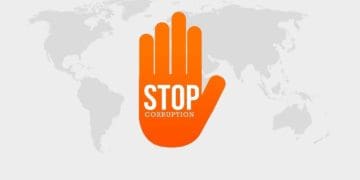 orange hand reading "stop corruption" on global map in grayscale