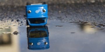 model blue VW van upside down in a puddle