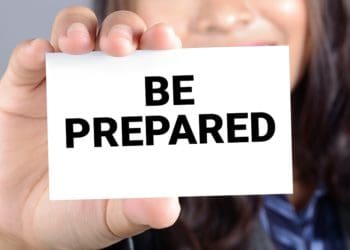 woman holding card that reads "be prepared"