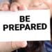woman holding card that reads "be prepared"