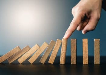 hand stopping falling dominos