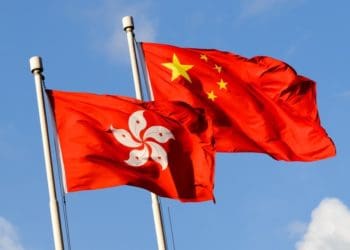 hong kong and china flags against blue sky