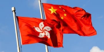hong kong and china flags against blue sky