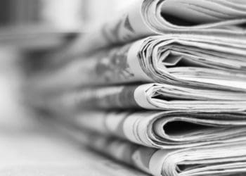 black and white image of stack of newspapers