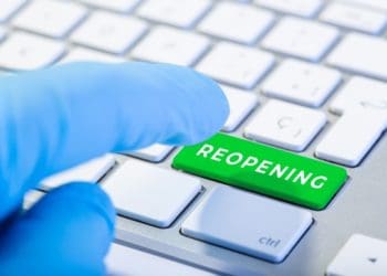 gloved hand pushing reopening button on keyboard