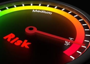 glowing gauge showing high risk on black risk management concept