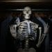 skeleton among clothes in dark closet