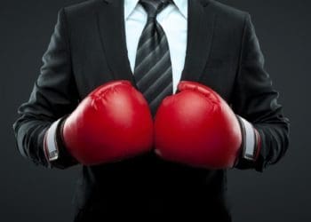 man in suit wearing red boxing gloves