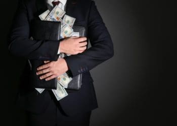 businessman holding portfolio with cash spilling out