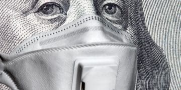 closeup of Benjamin Franklin's face on the $100 bill wearing medical mask