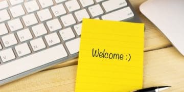 welcome written on yellow post-it note stuck to keyboard