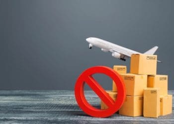cardboard boxes and airplane lifting off with prohibited symbol on gray background