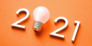 2021 with light bulb in place of zero on orange background
