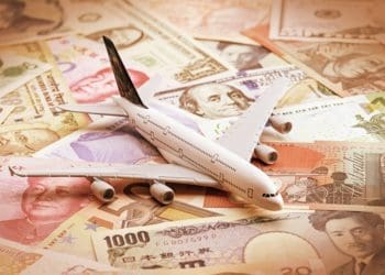 miniature airplane on global currency