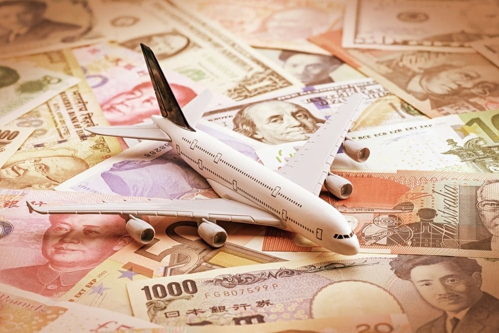 miniature airplane on global currency