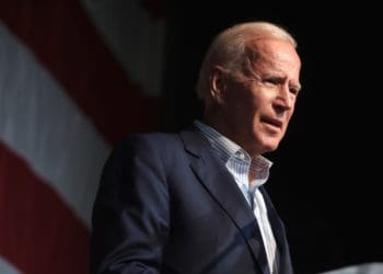 Joe Biden on stage in front of an American flag