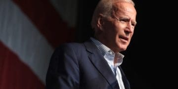 Joe Biden on stage in front of an American flag