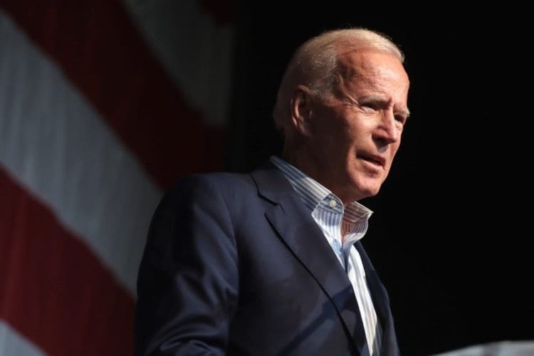 Joe Biden on stage in front of an American flag