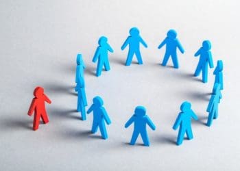 red stick figure standing outside circle of blue stick figures