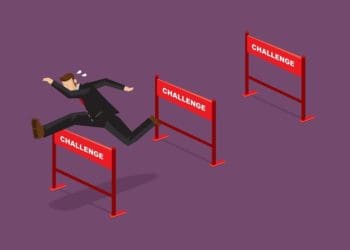 businessman jumping over hurdles with text challenge on them
