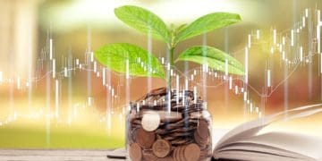 green plant growing on glass jar with coins