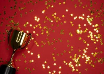 gold cup award on red background with stars