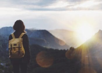 woman looking at horizon from mountain top