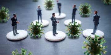 mini businessmen separated by COVID particles