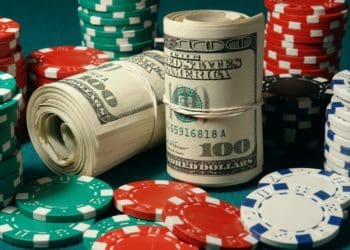 rolls of cash amid stacks of poker chips