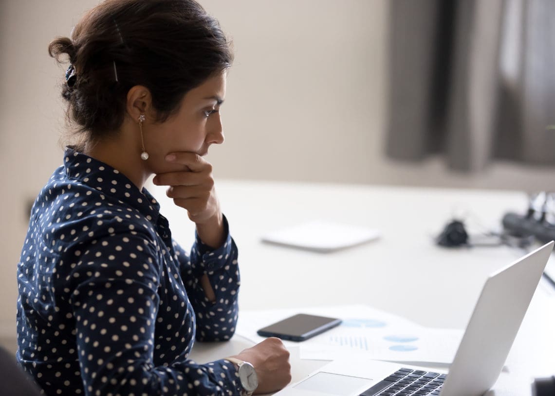 A director contemplates information at her desk.