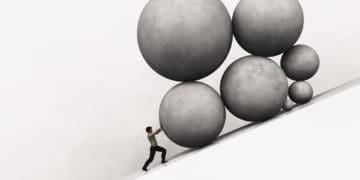 man piushing rocks uphill to symbolize burden