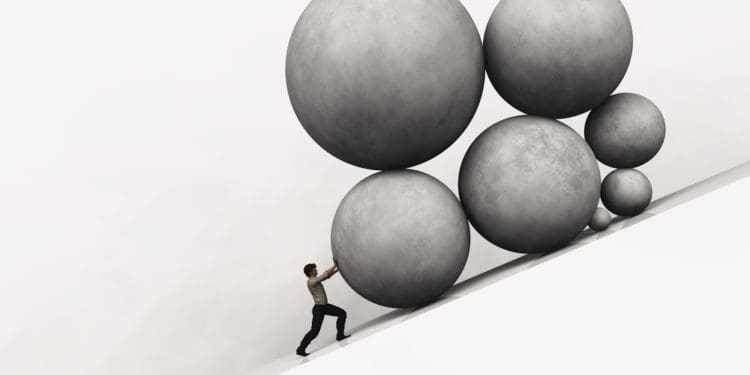 man piushing rocks uphill to symbolize burden