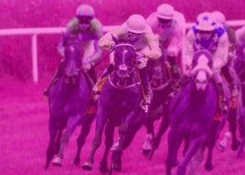 Horses and riders in a horse race round a corner on the track