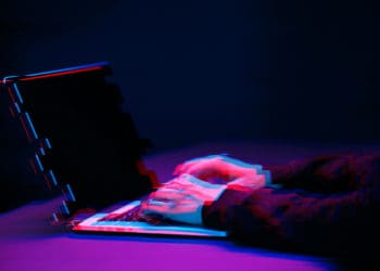 A pixilated image of a hacker at work, perhaps on extortionware.
