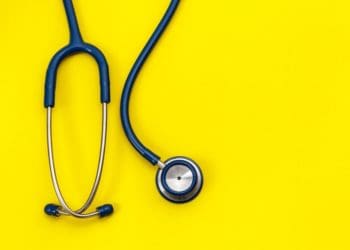 a stethoscope hangs over a yellow background